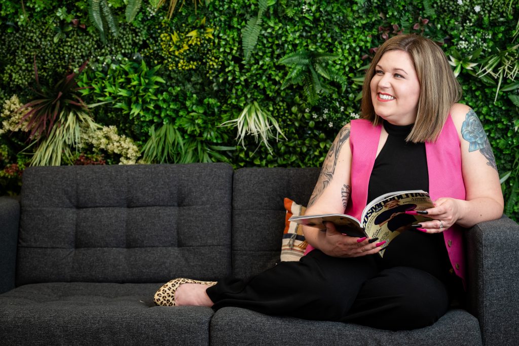 Amie sitting on sofa with a magazine